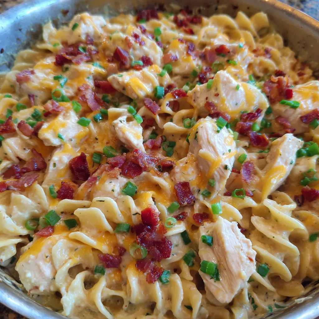Close-up of pasta coated in creamy sauce with chicken and cheese